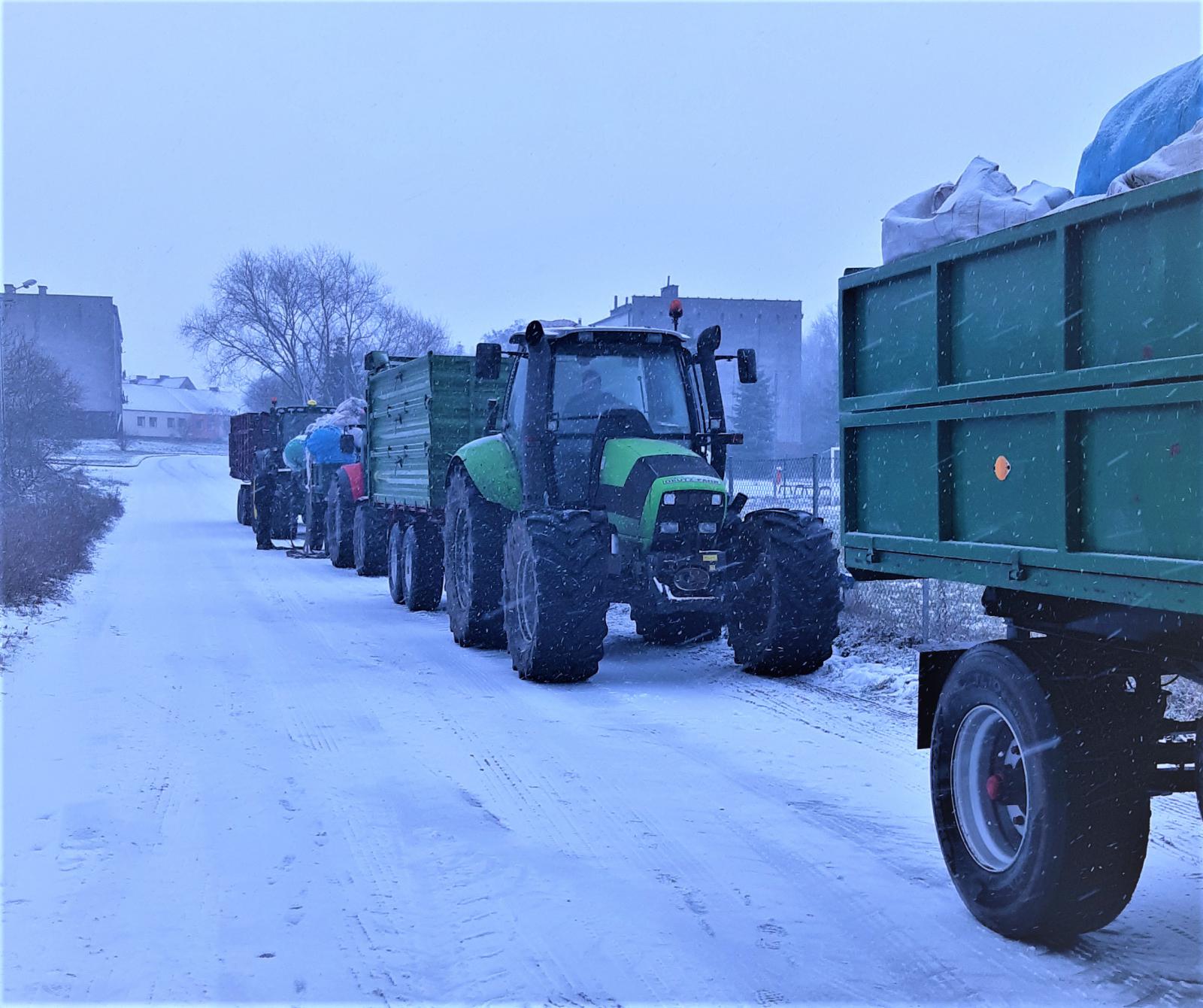 Traktory ciągnące przyczepy załądowane odpadami rolniczymi